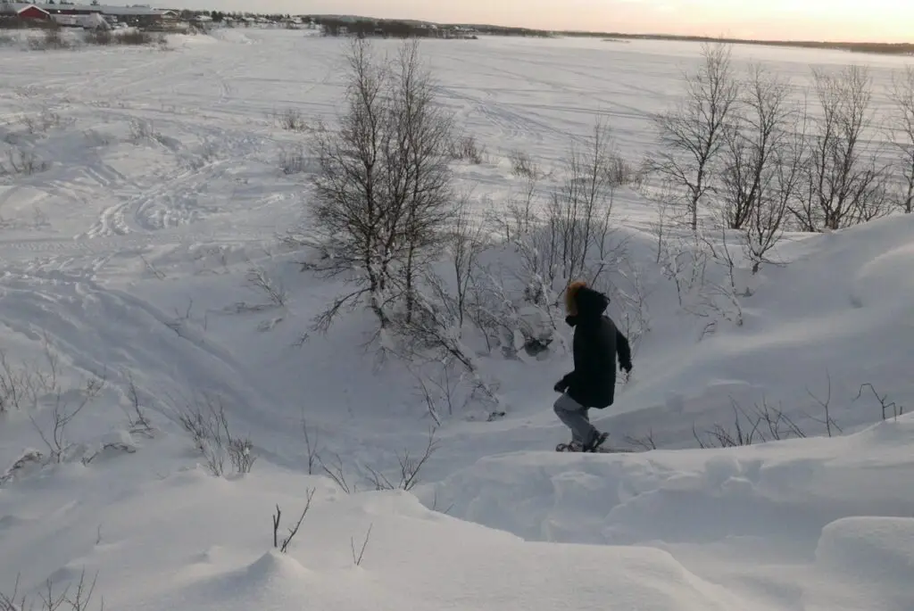 descendre une pente enneigée en raquette à neige TSL en laponie suédoise