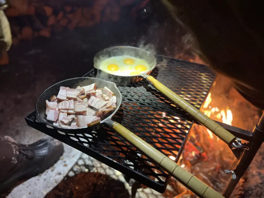 lard et oeuf cuisiné au feu de bois pour le petit déjeuner